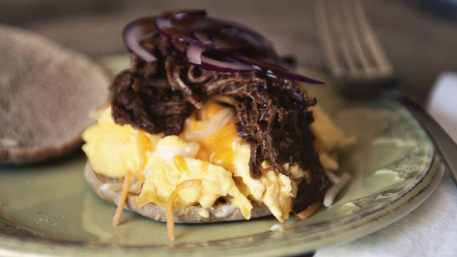 BBQ brisket egg sandwich layered with brisket and a runny egg.