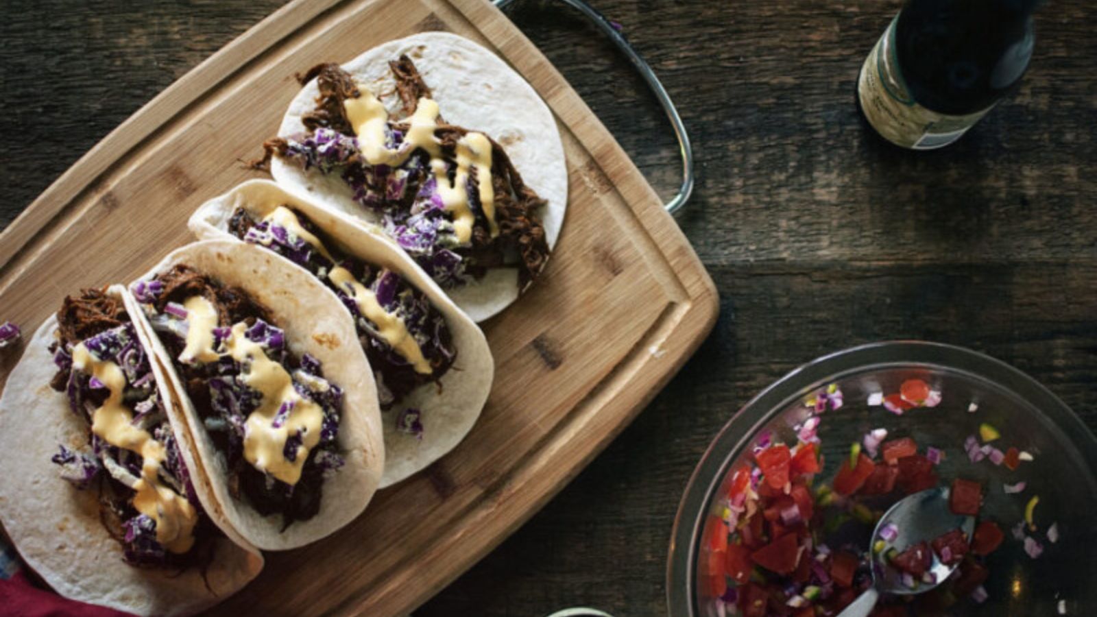 BBQ brisket tacos topped with Dubliner cheese sauce and fresh garnish.