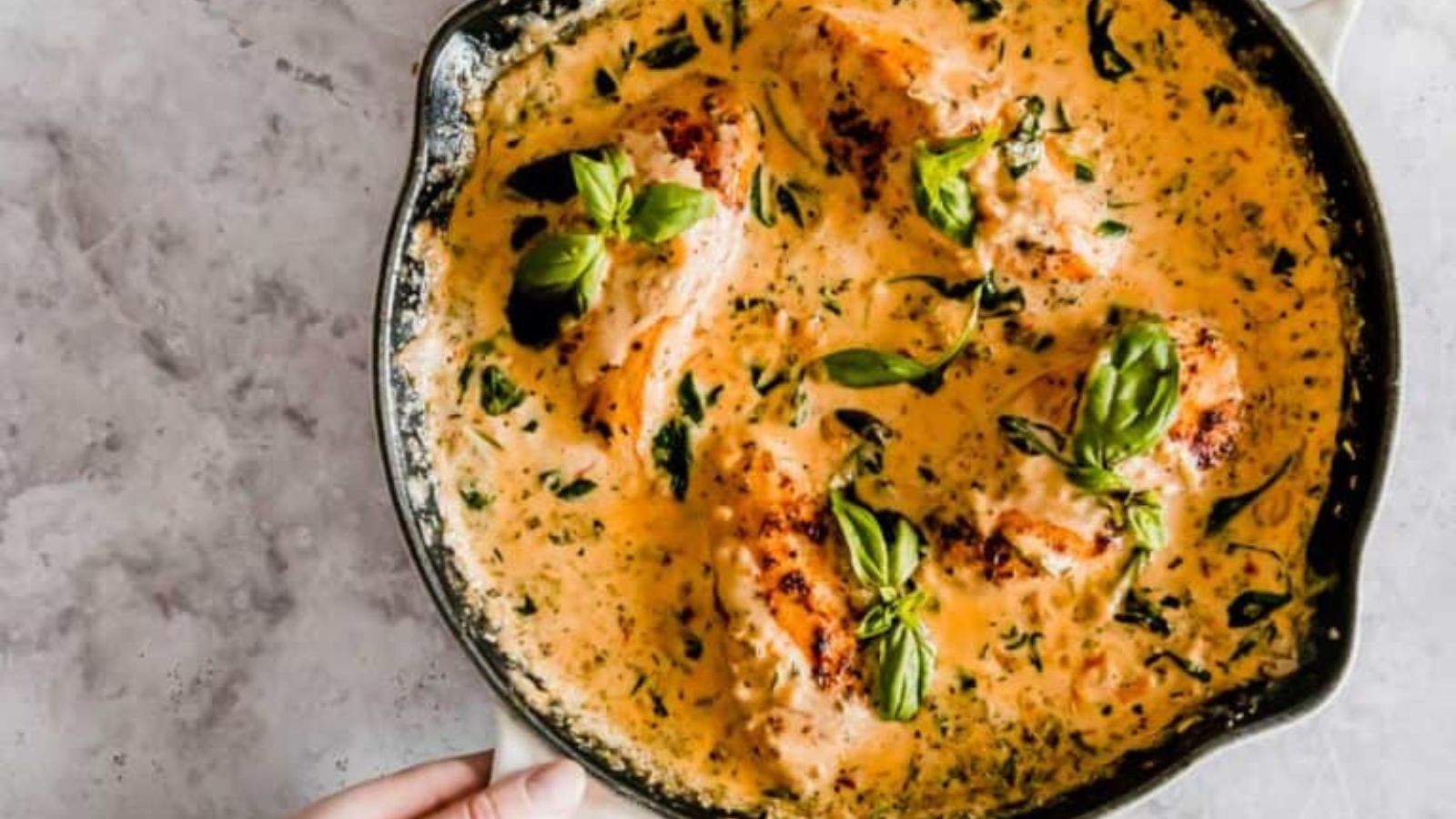 Creamy Tuscan chicken with spinach and sun-dried tomatoes simmering in rich cream sauce.