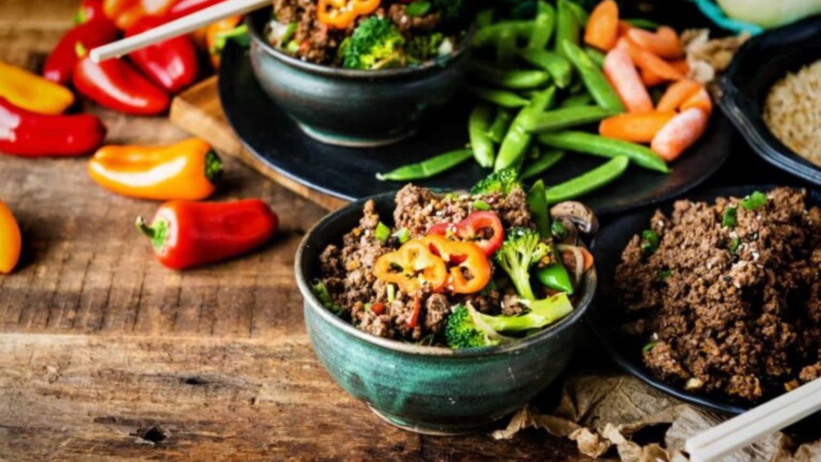 Beef bowls served with rice and vegetables drizzled with savory Korean-style sauce.