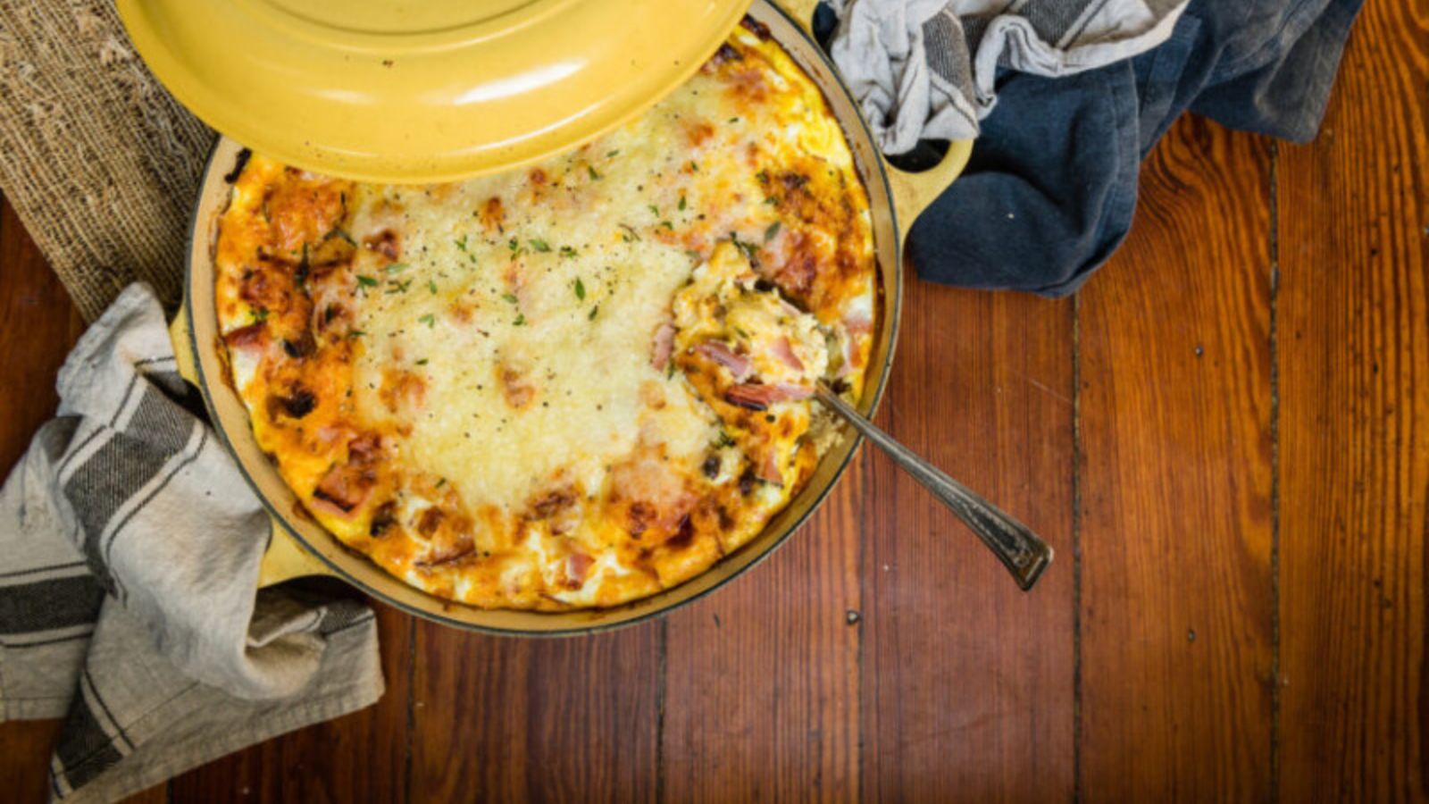 Breakfast strata layered with ham, bread, and eggs baked until golden.