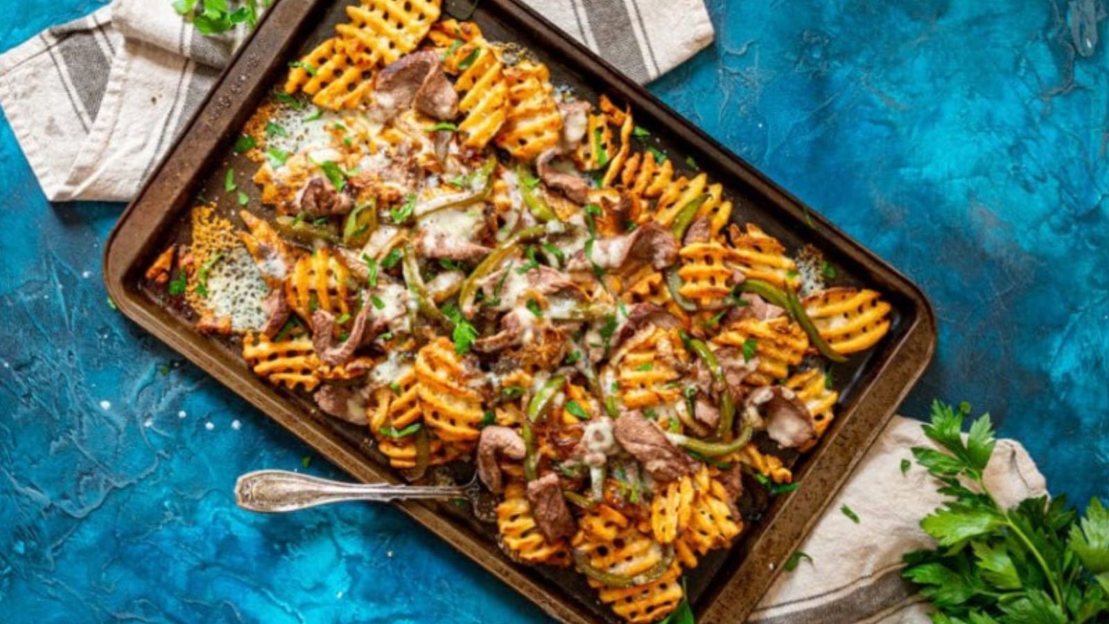 Philly cheesesteak fries loaded with steak, peppers, and melted cheese.