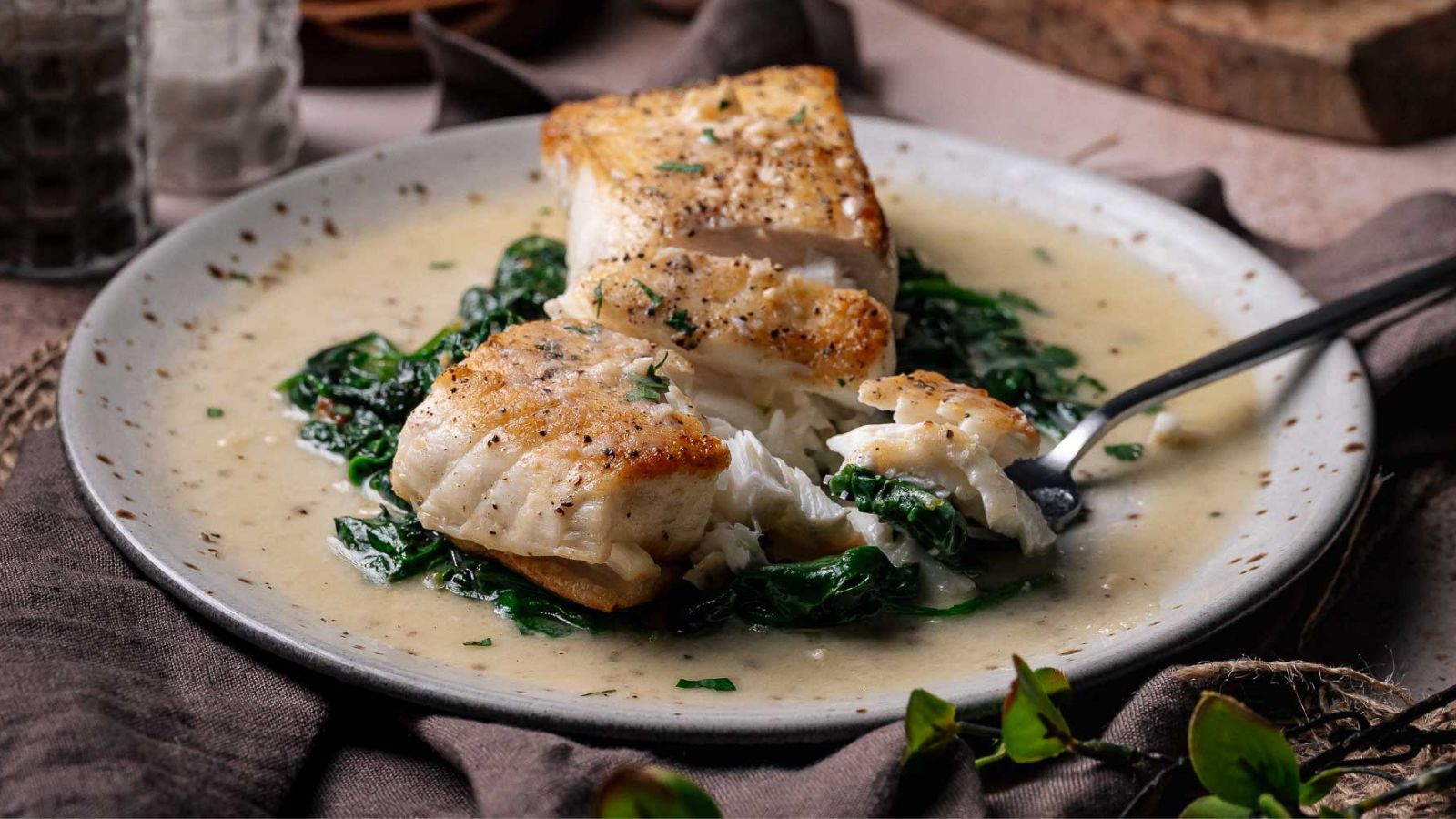 Halibut seared and served with spinach and lemon butter sauce.