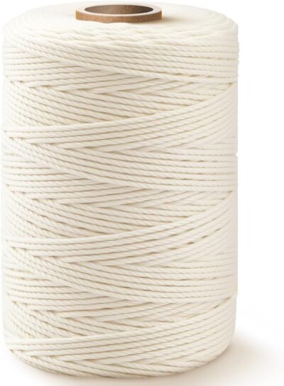 A large spool of white cotton twine with a brown cardboard core, neatly wound in even layersโperfect for tying roasts when learning how to carve a prime rib.