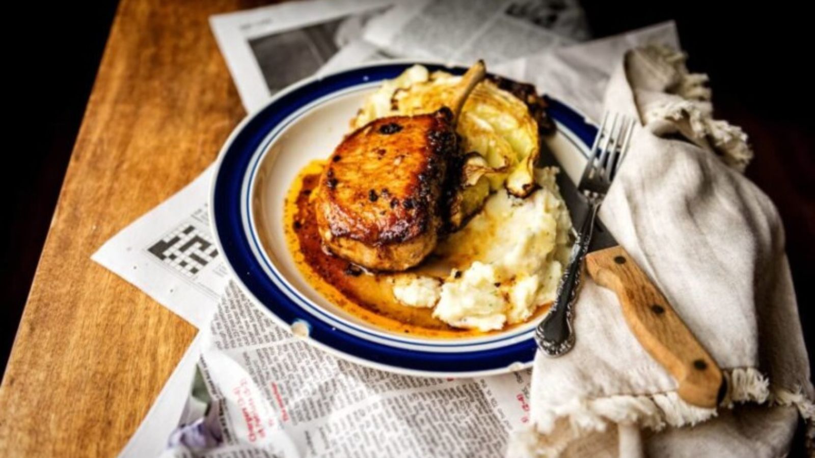 Bone-in pork chop baked until exterior browns deeply with juices settling along the bone.