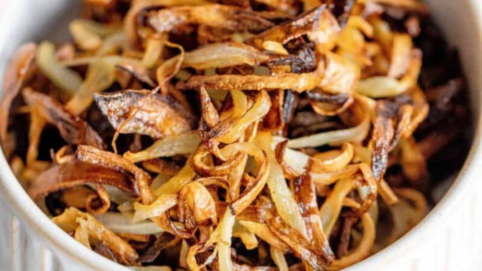 Crispy air fryer onions golden brown piled high in a serving bowl.