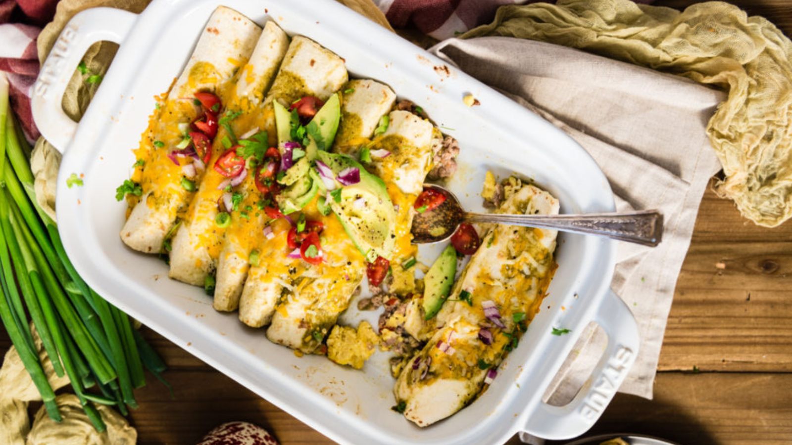 Breakfast enchiladas topped with salsa verde and melted cheese baked golden.