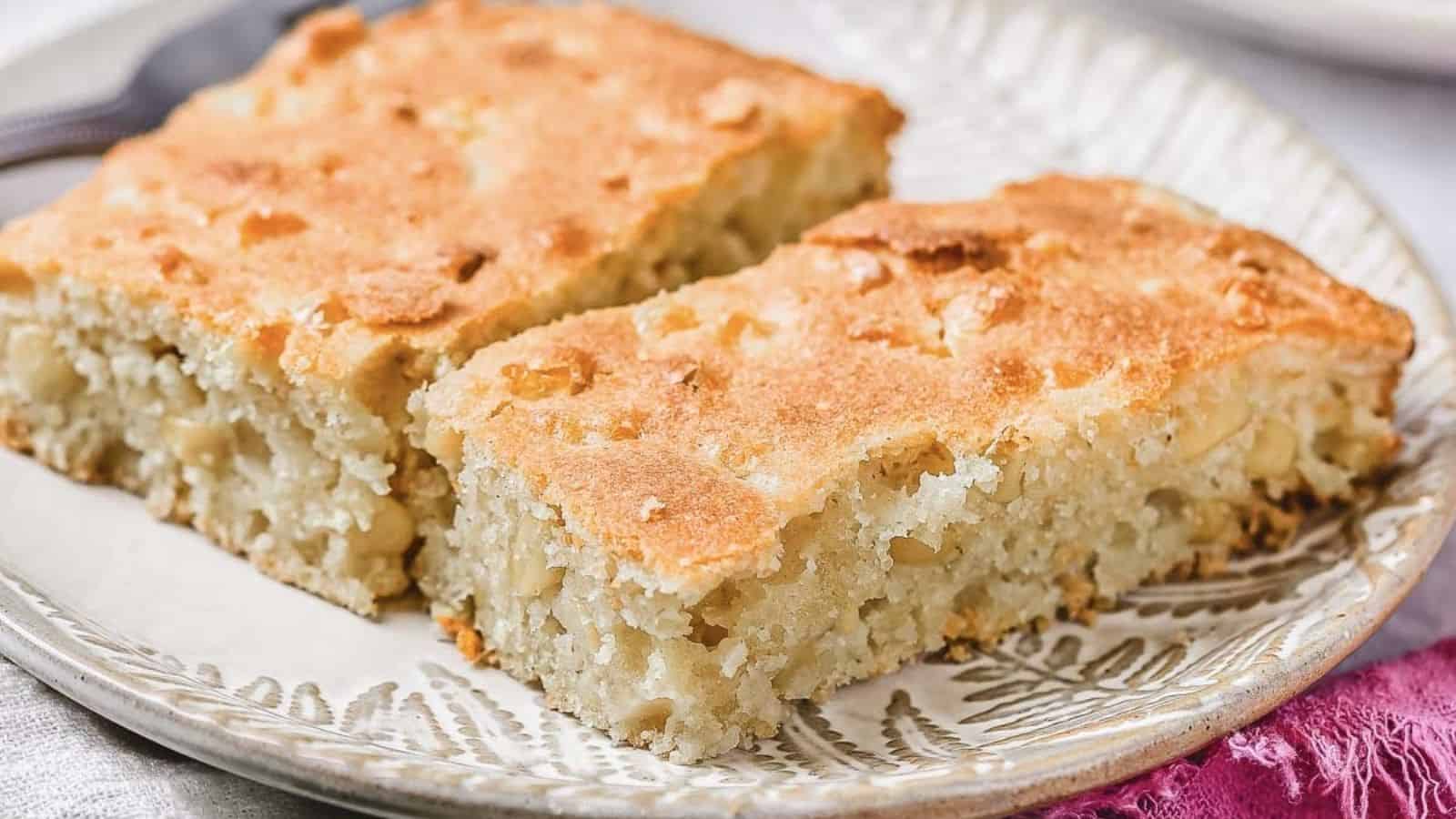 Two rectangular slices of light golden-brown cake with a slightly crumbly texture are placed side by side on a patterned plate.