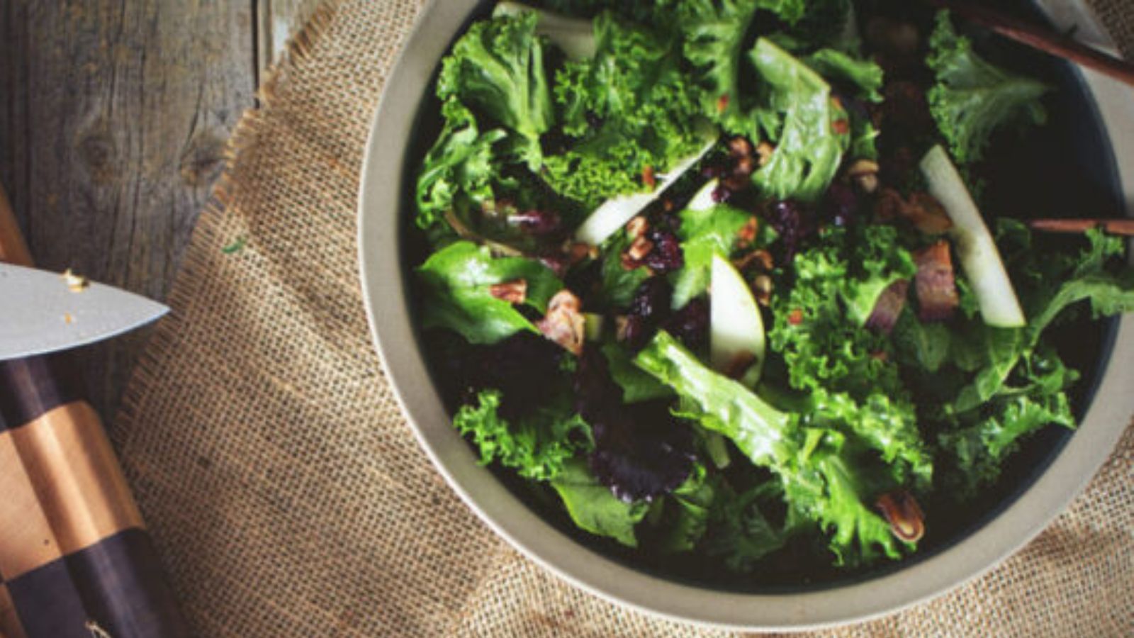 Salad with kale, apples, and warm bacon vinaigrette tossed lightly.