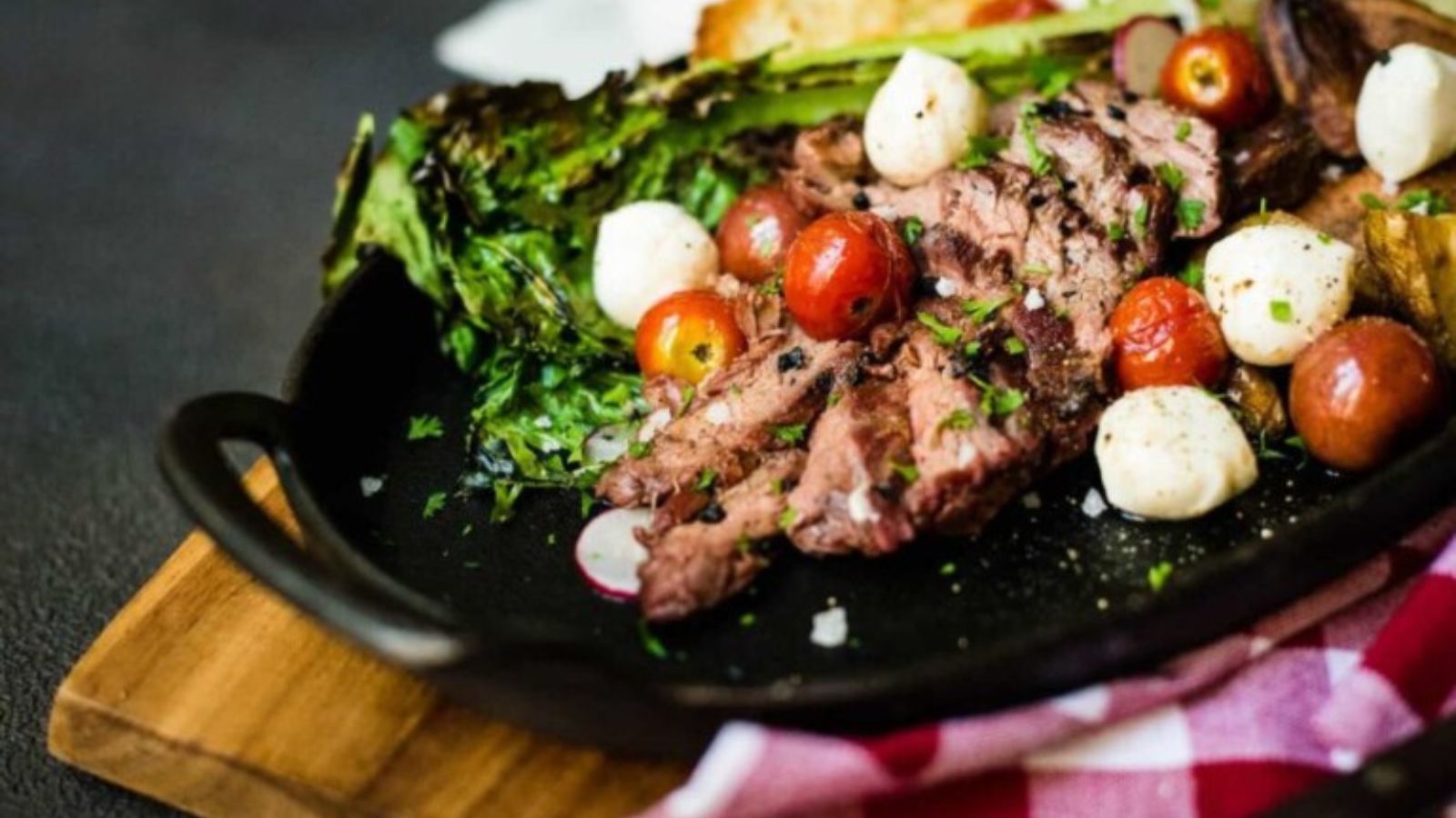 Bavette steak sliced over greens with rustic grilled char.