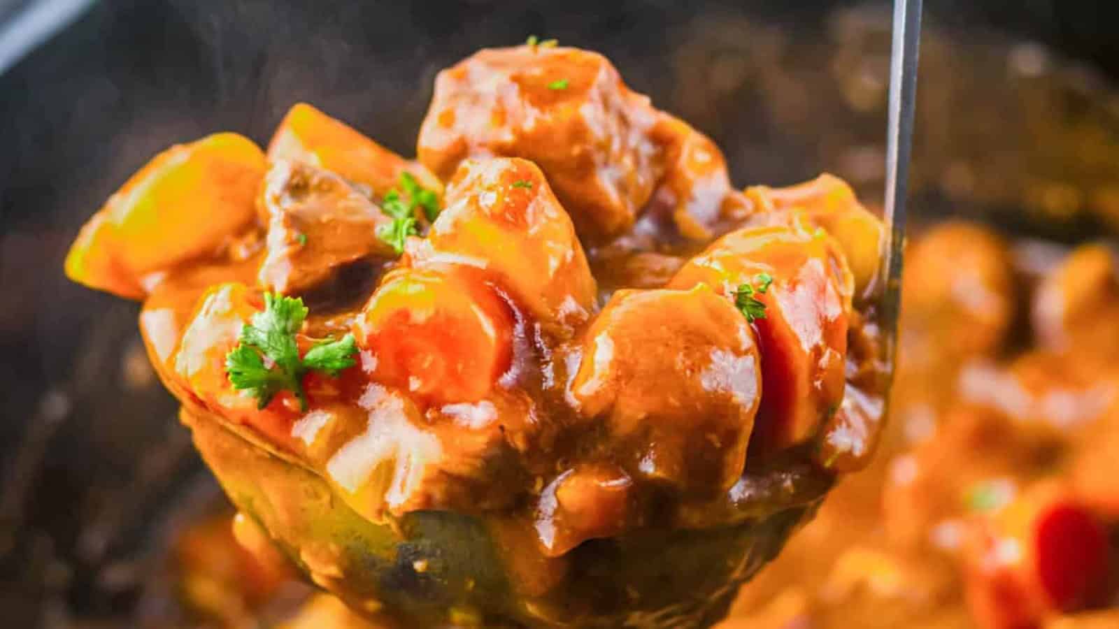 A ladle of beef stew with carrots, potatoes, and parsley in a rich brown sauce.