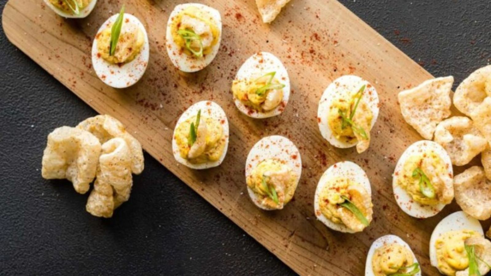 Deviled eggs topped with chicharrones and spicy seasoning.