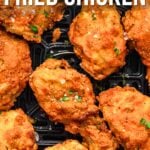 Crispy pieces of fried chicken in an air fryer basket, garnished with herbs and coarse salt. Text reads: "How to Make Air Fryer Fried Chicken.