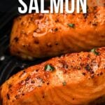 Close-up of cooked salmon fillets in an air fryer basket with seasoning, accompanied by the text "How to Make Air Fryer Salmon.