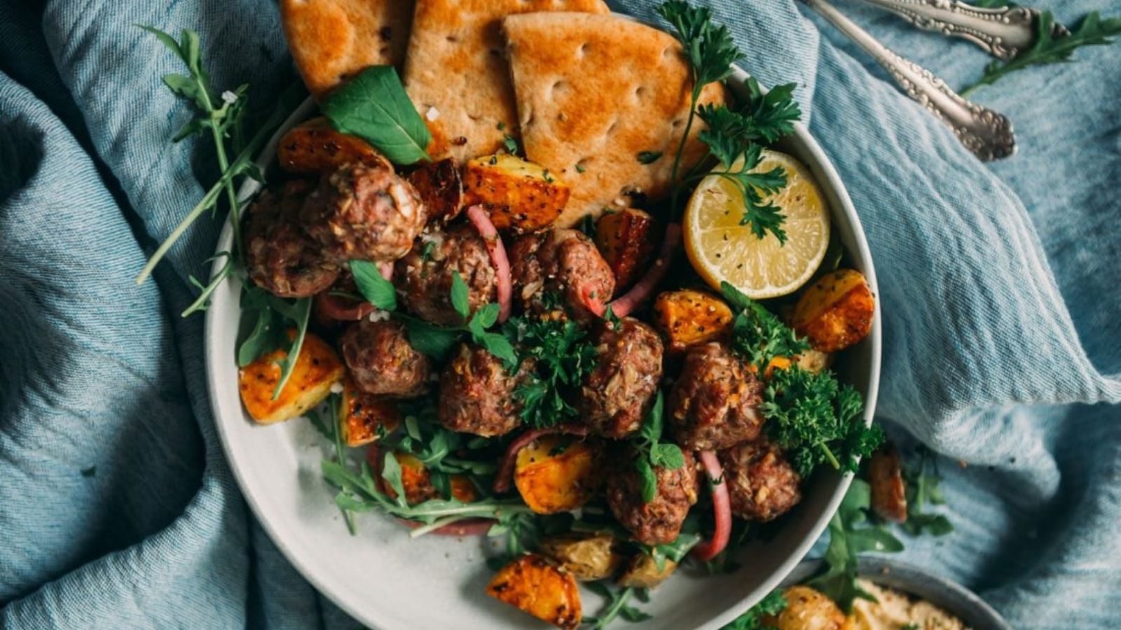 Lamb meatballs baked golden with herbs and served in sauce.