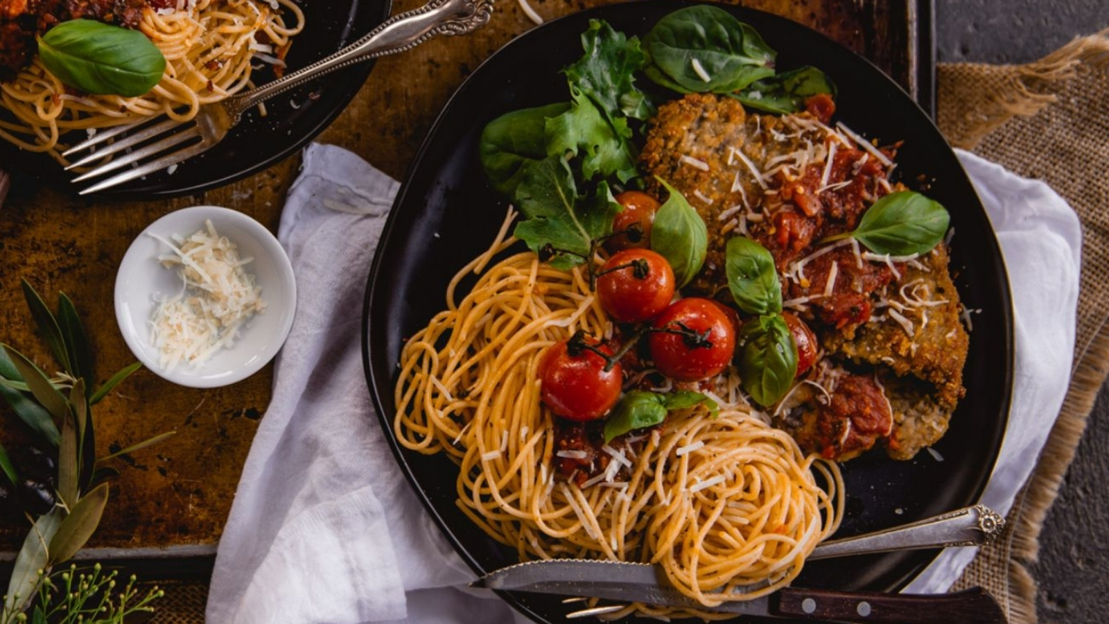 Breaded beef cutlet fried crisp and topped with melted cheese and rich tomato sauce pooling underneath.