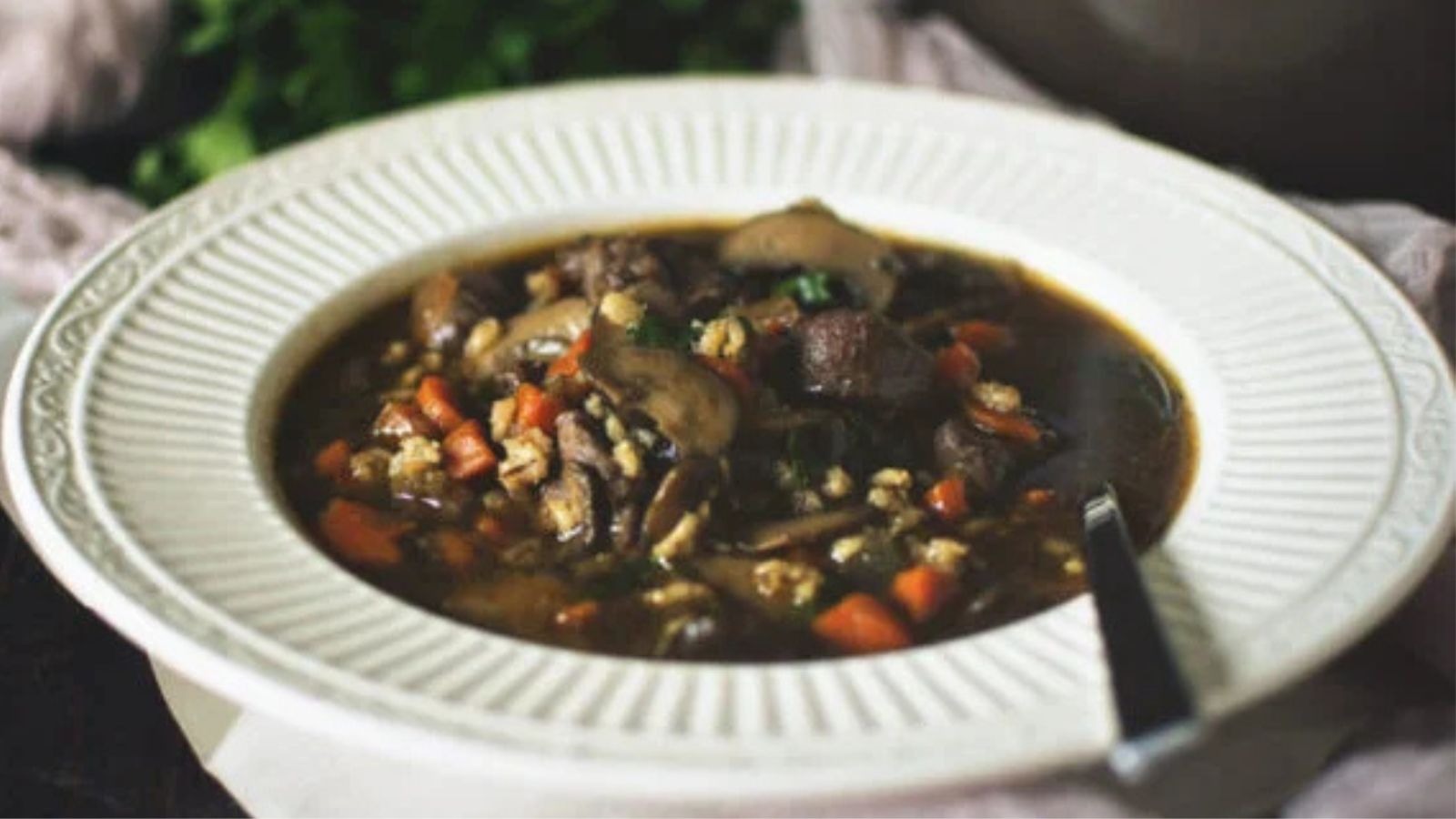 Beef and barley soup simmered hearty with vegetables and broth.