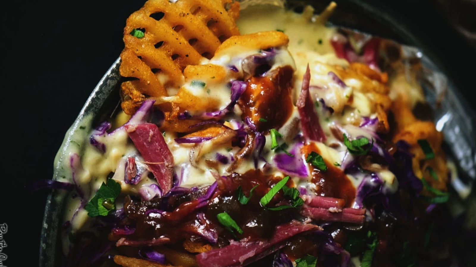 Nachos topped with corned beef, melted herbed whiskey cheese sauce, and crisp tortilla chips.