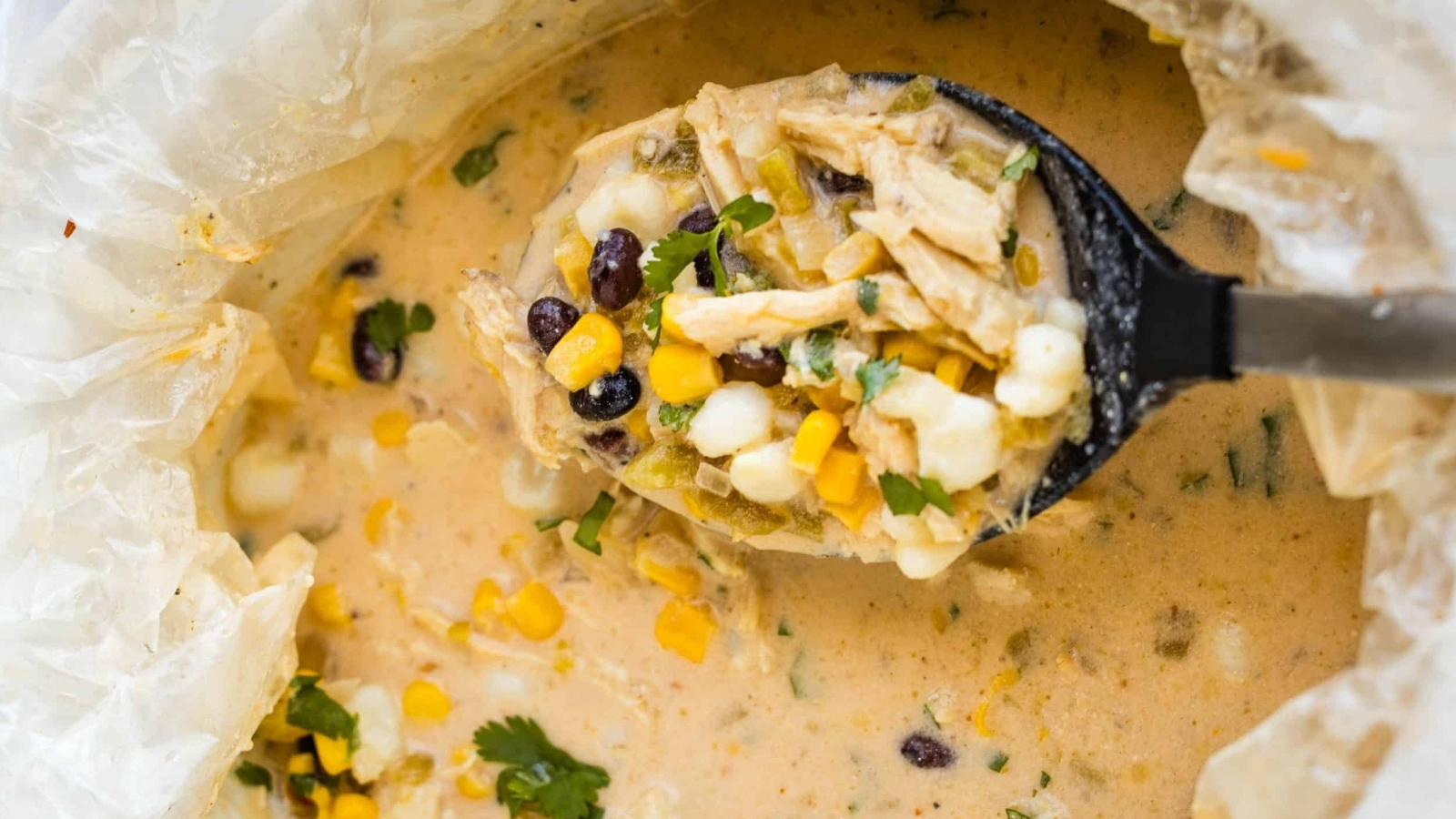 A bowl of mexican chicken chowder with corn and black beans.