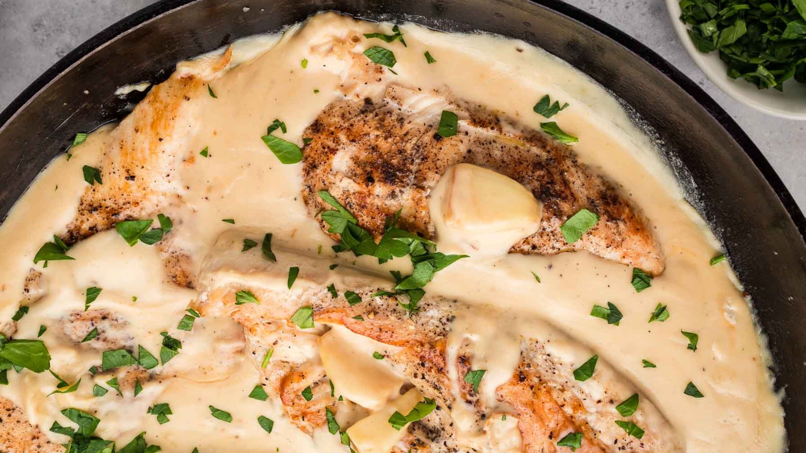 Seared chicken breasts in a creamy white sauce, topped with fresh chopped parsley, make this skillet meal a standout among meat dinners.