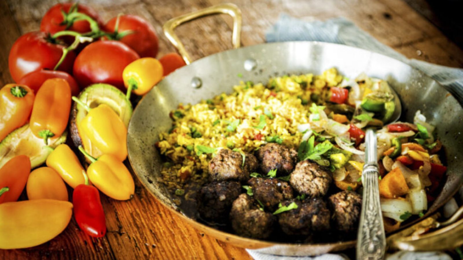 Lamb meatballs spiced with cumin drizzled with chimichurri and plated neatly.