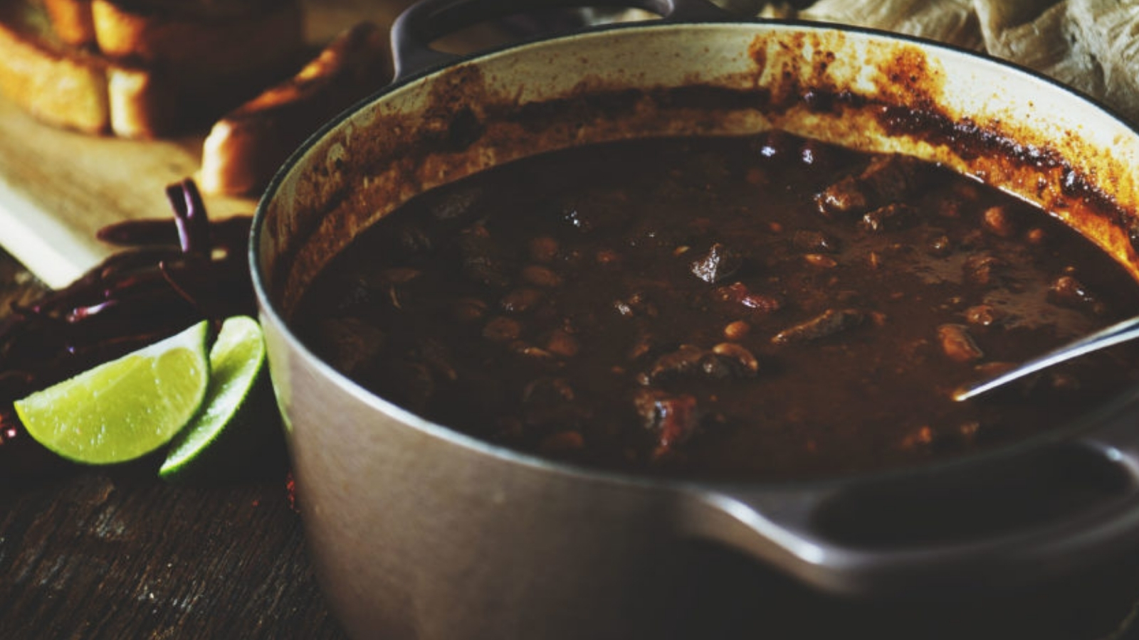 Chili baked in Dutch oven with browned edges and deep heat.