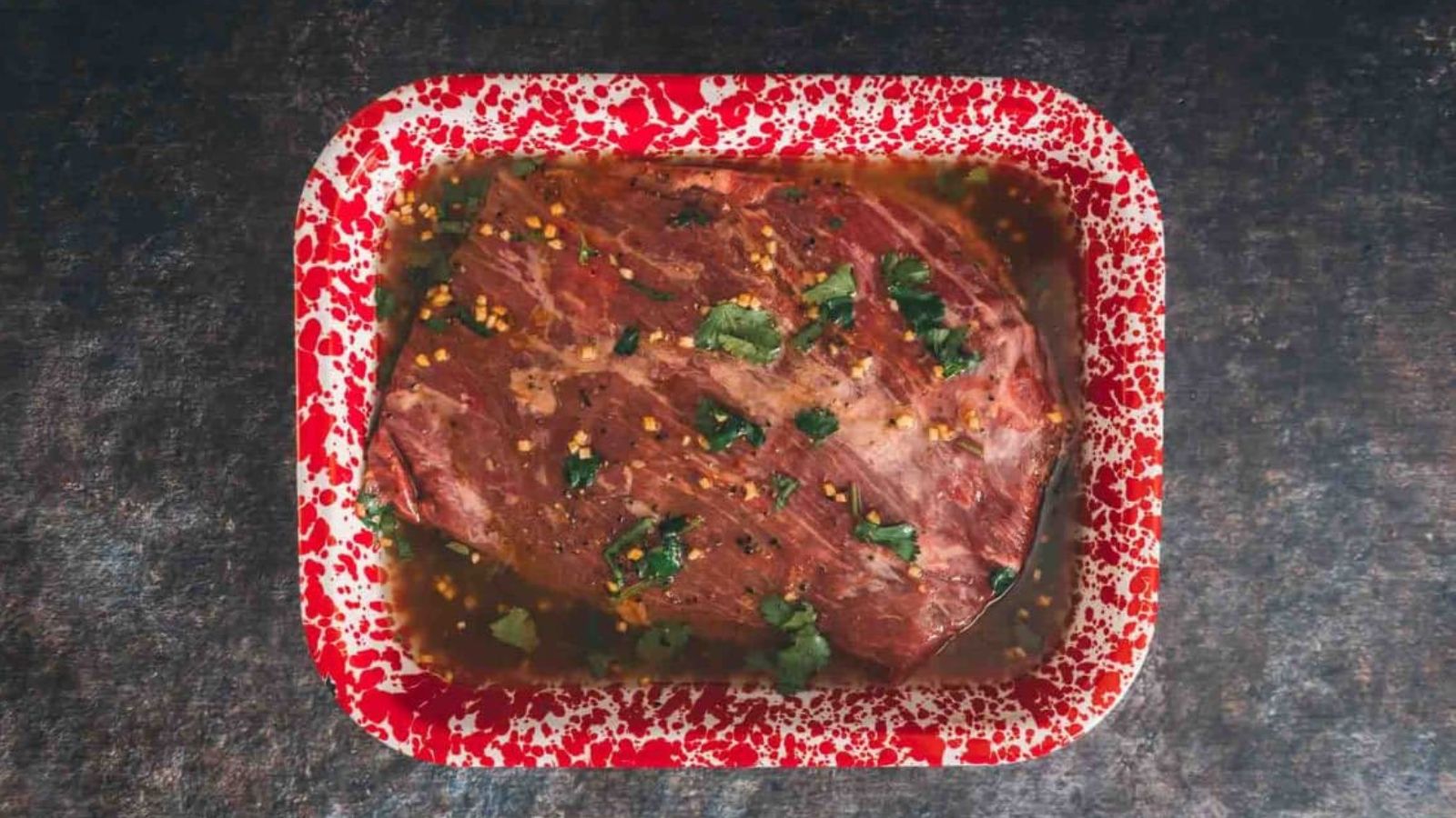 Flank steak marinade blended with soy, garlic, herbs, and citrus in a bowl.