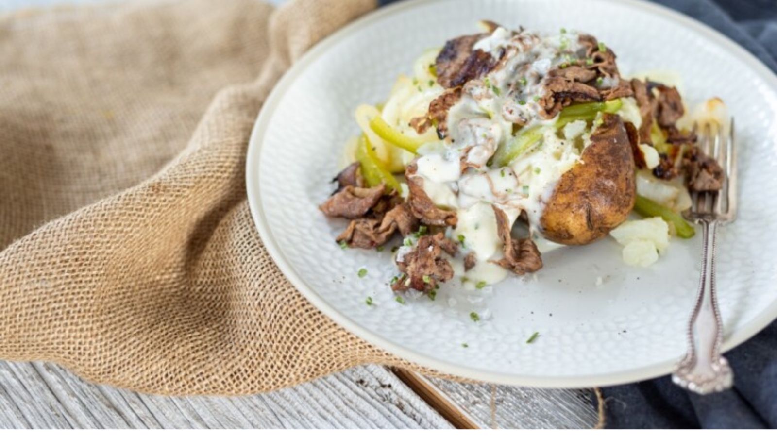 Baked potato stuffed with Philly cheesesteak filling.