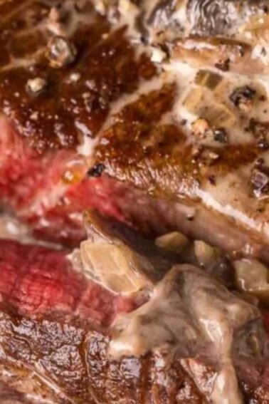 Close-up of sliced steak cooked medium-rare, topped with a creamy mushroom and onion sauce, garnished with fresh herbs—a timeless choice for Classic Dinners.