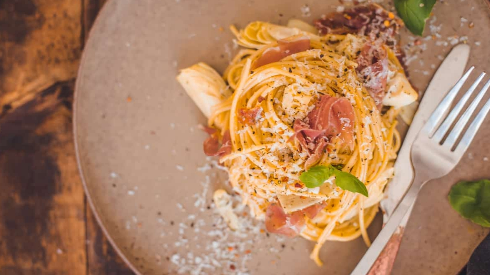 Carbonara with prosciutto tossed creamy with egg and cheese.