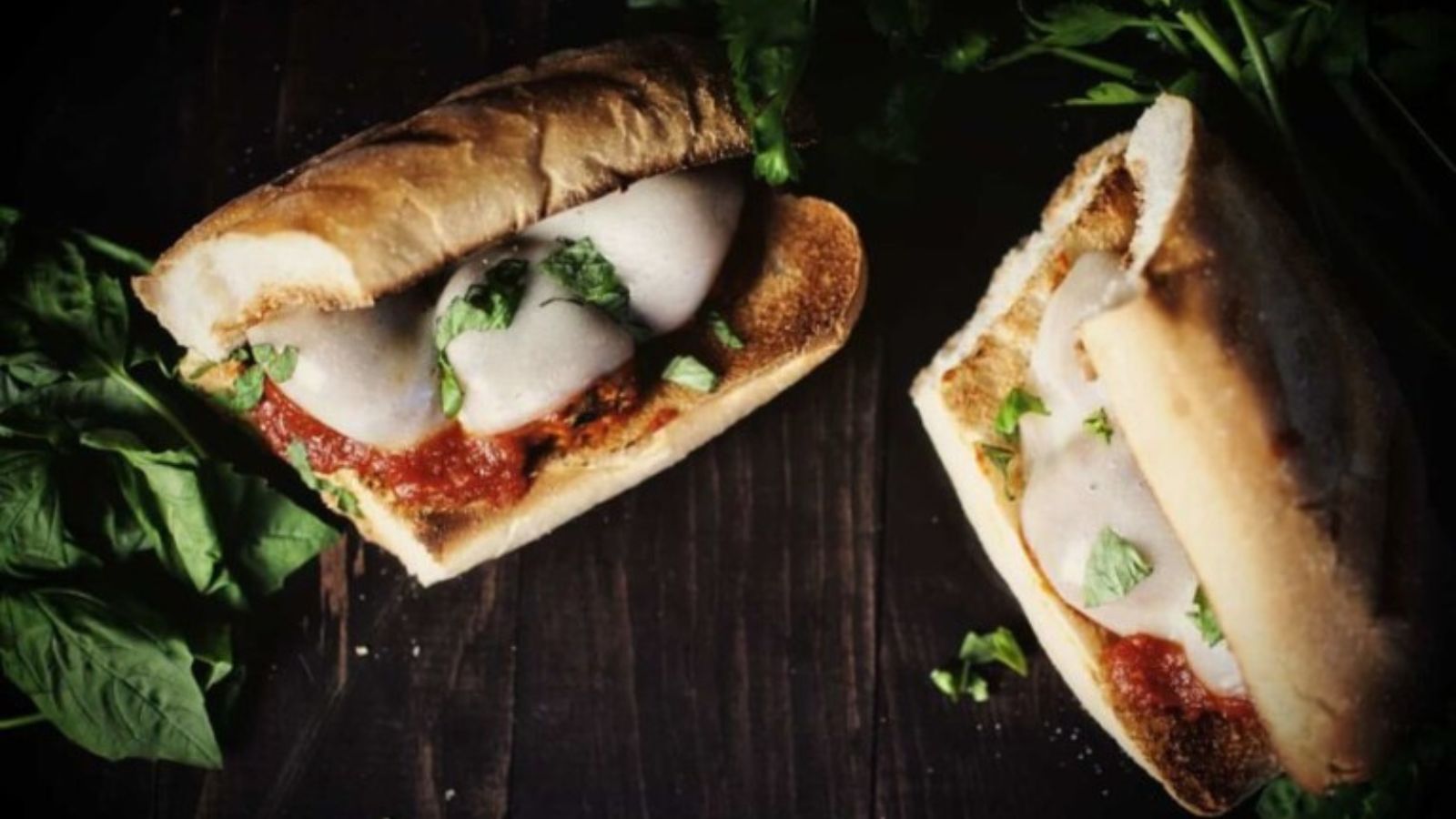 Turkey meatball hoagies topped with melted cheese.