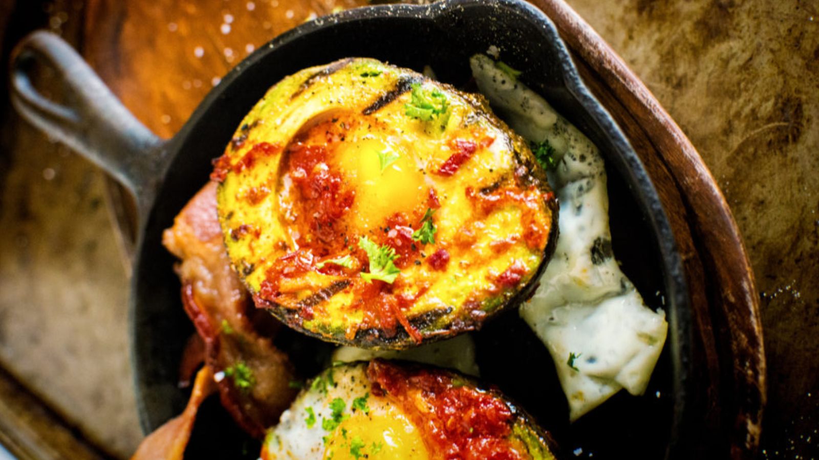 Avocado halves baked with eggs seasoned with grilled harissa.