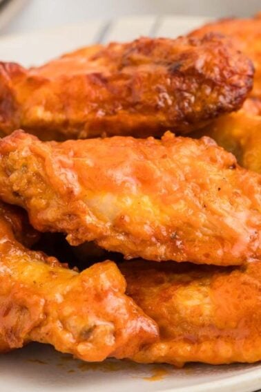 A plate of buffalo chicken wings with a side of celery sticks.