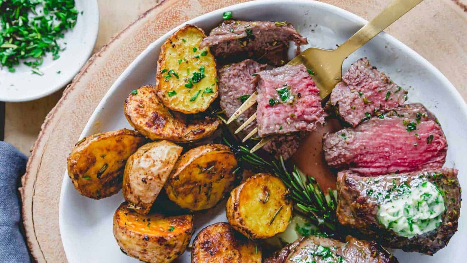 Air fryer filet mignon with sliced potatoes.