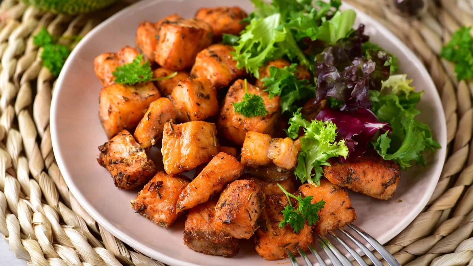 Air Fryer Salmon Bites and a salad on a plate with a fork.