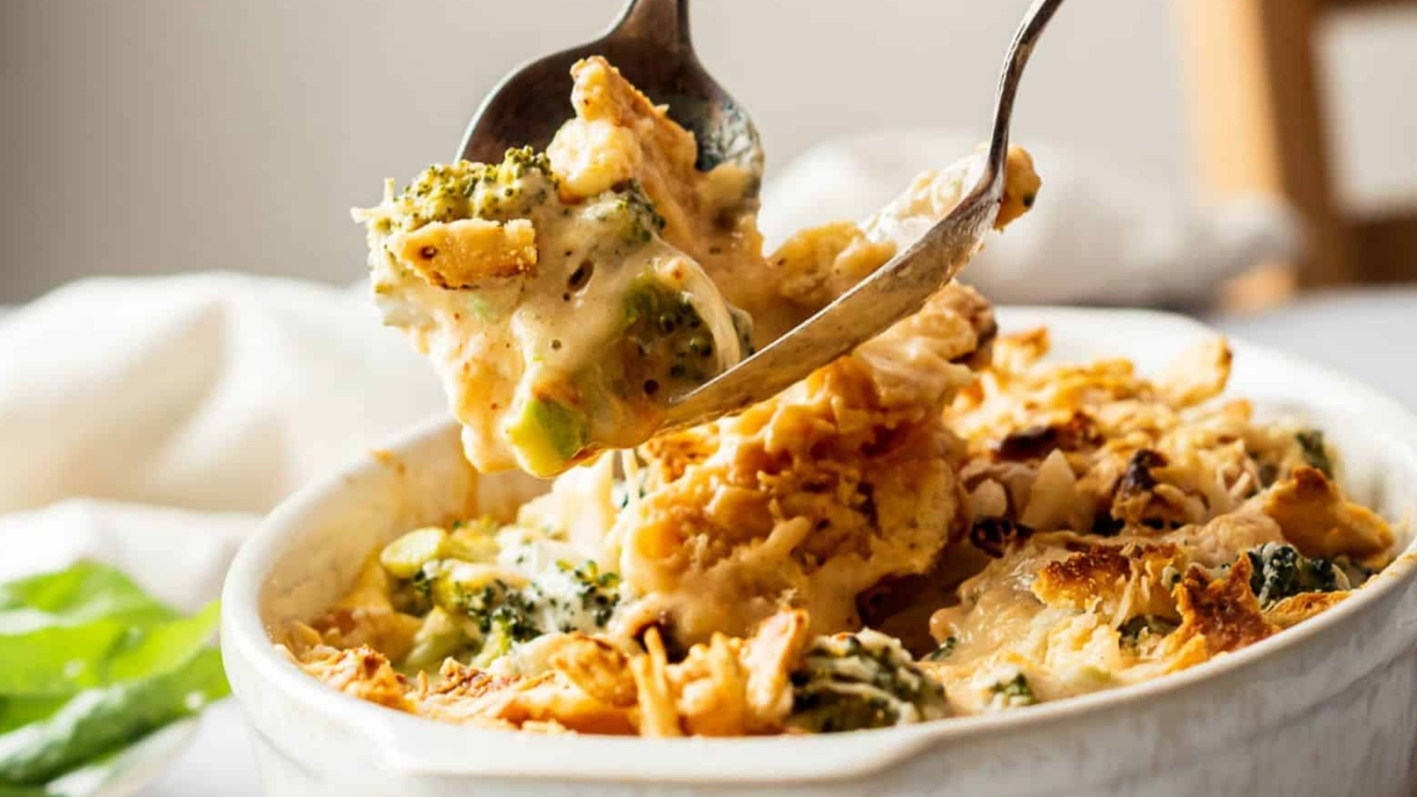 Someone serving broccoli casserole.