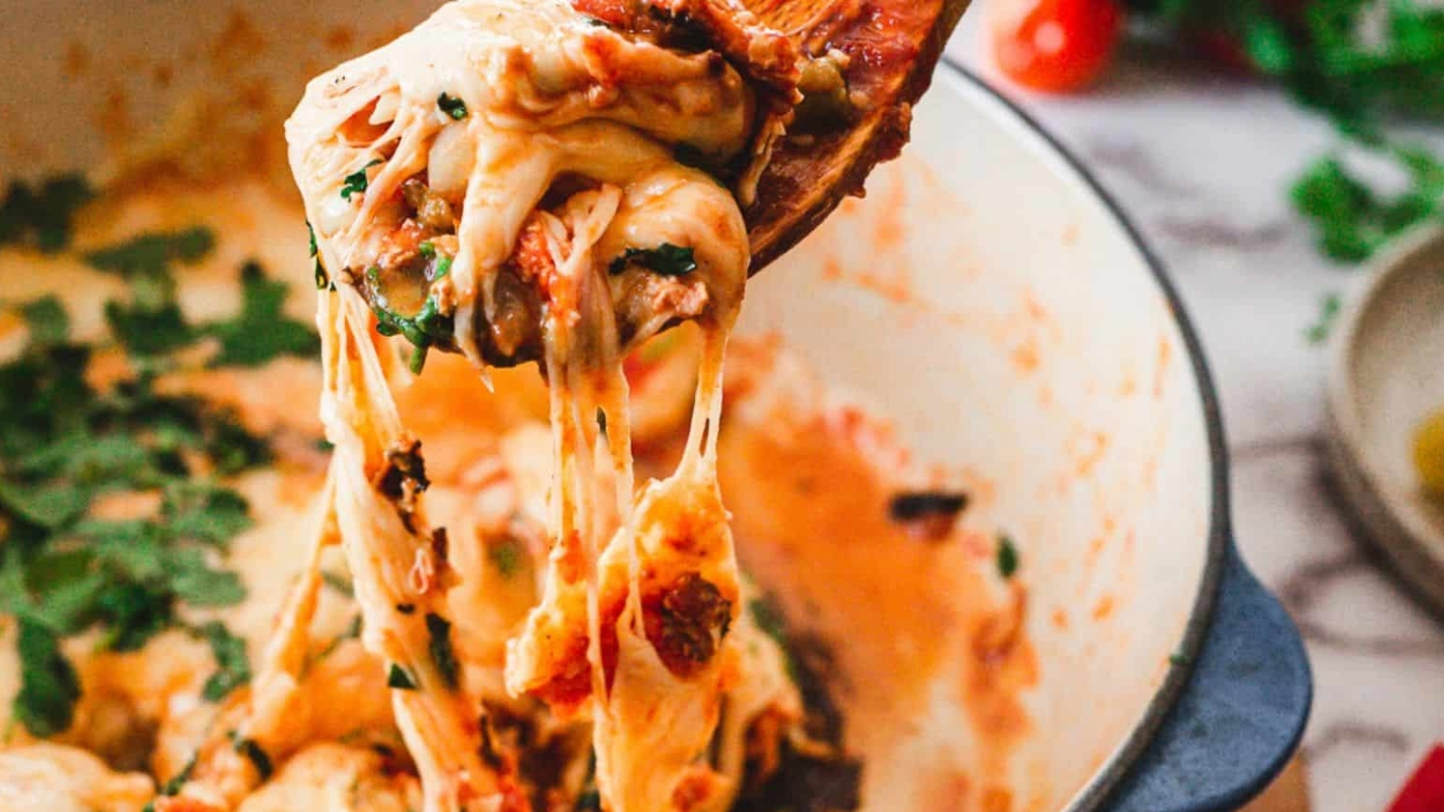 A person scooping a dish of eggs in a skillet.