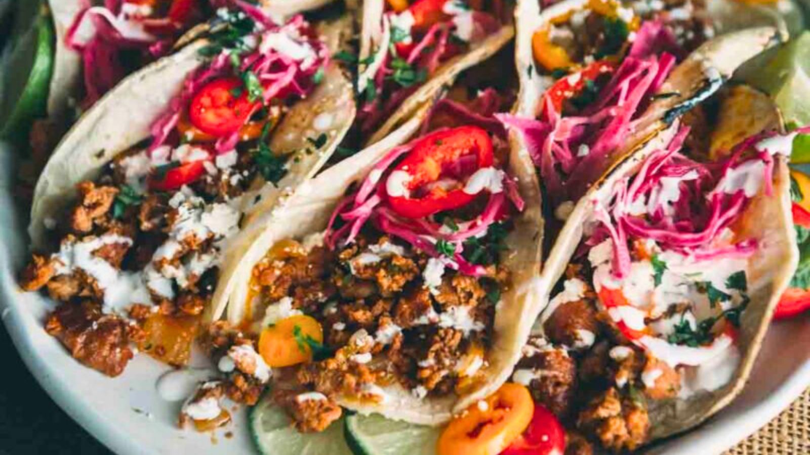 Chorizo street tacos topped with onions, cilantro, and lime on soft tortillas.
