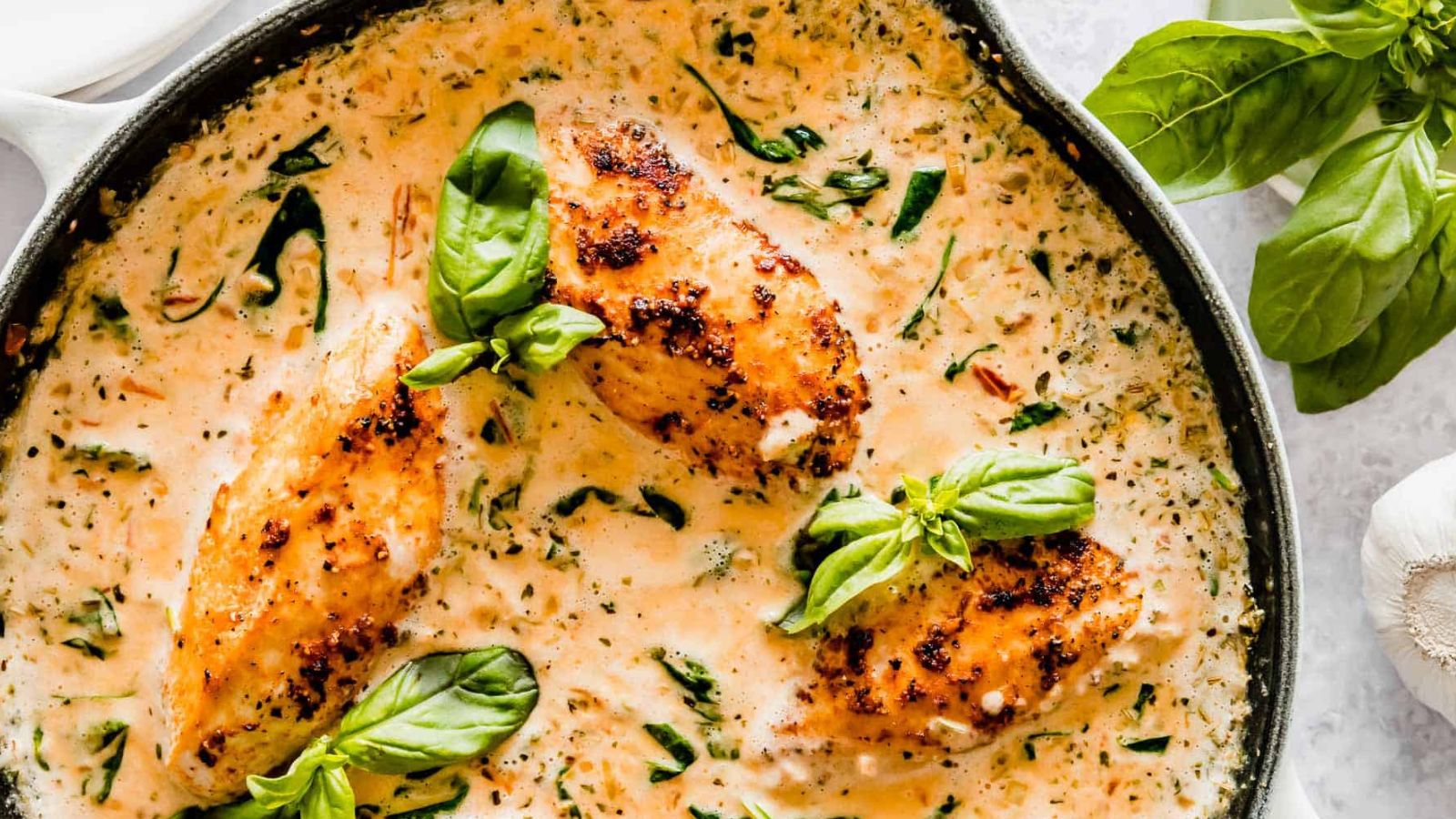 Creamy Tuscan chicken with spinach and sun-dried tomatoes simmering in rich cream sauce.