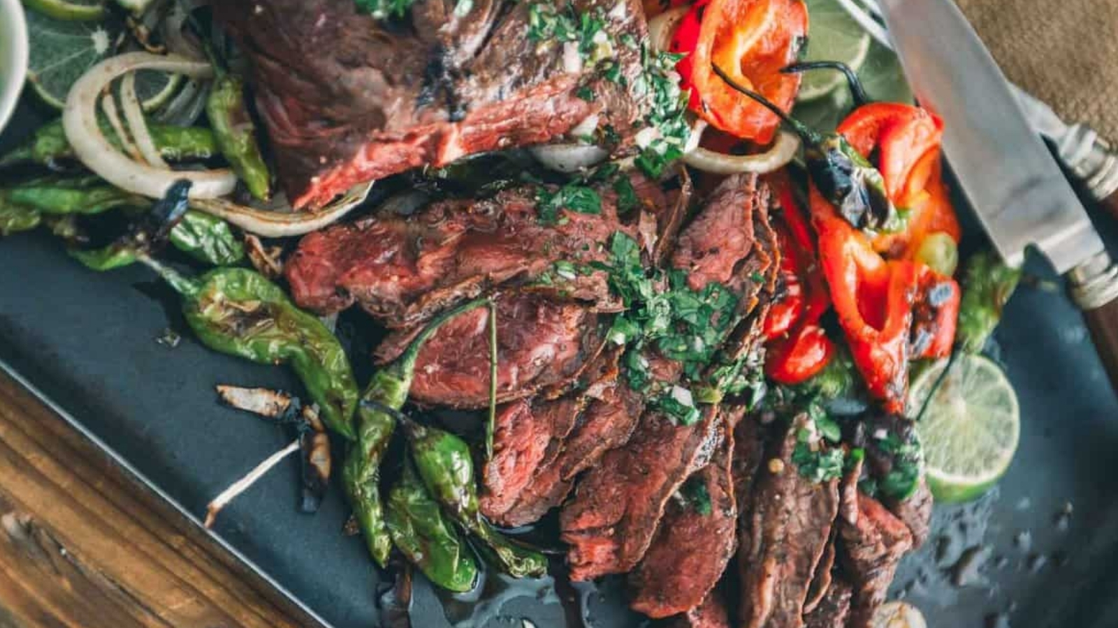 Grilled hanger steak sliced thin with juices pooling beneath the seared edges.