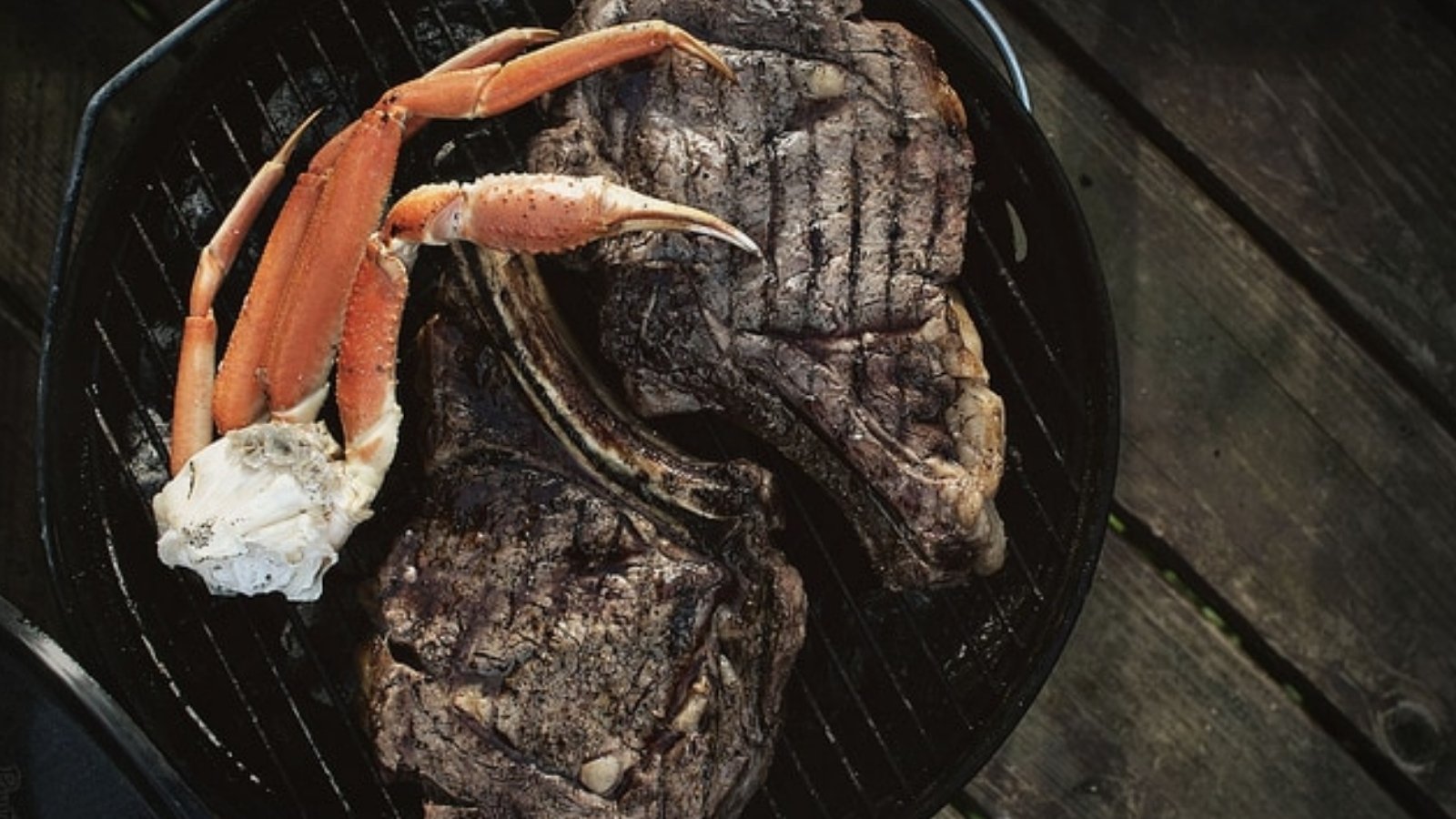 Rib eyes grilled with sweet crab legs served alongside.