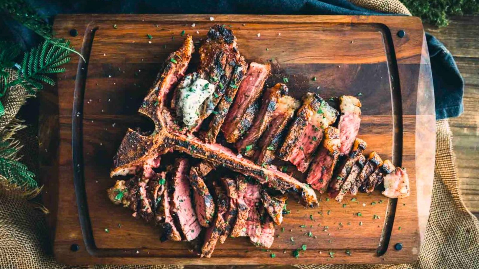 Grilled T-bone steak with bold sear showing filet and strip sides cooked evenly.