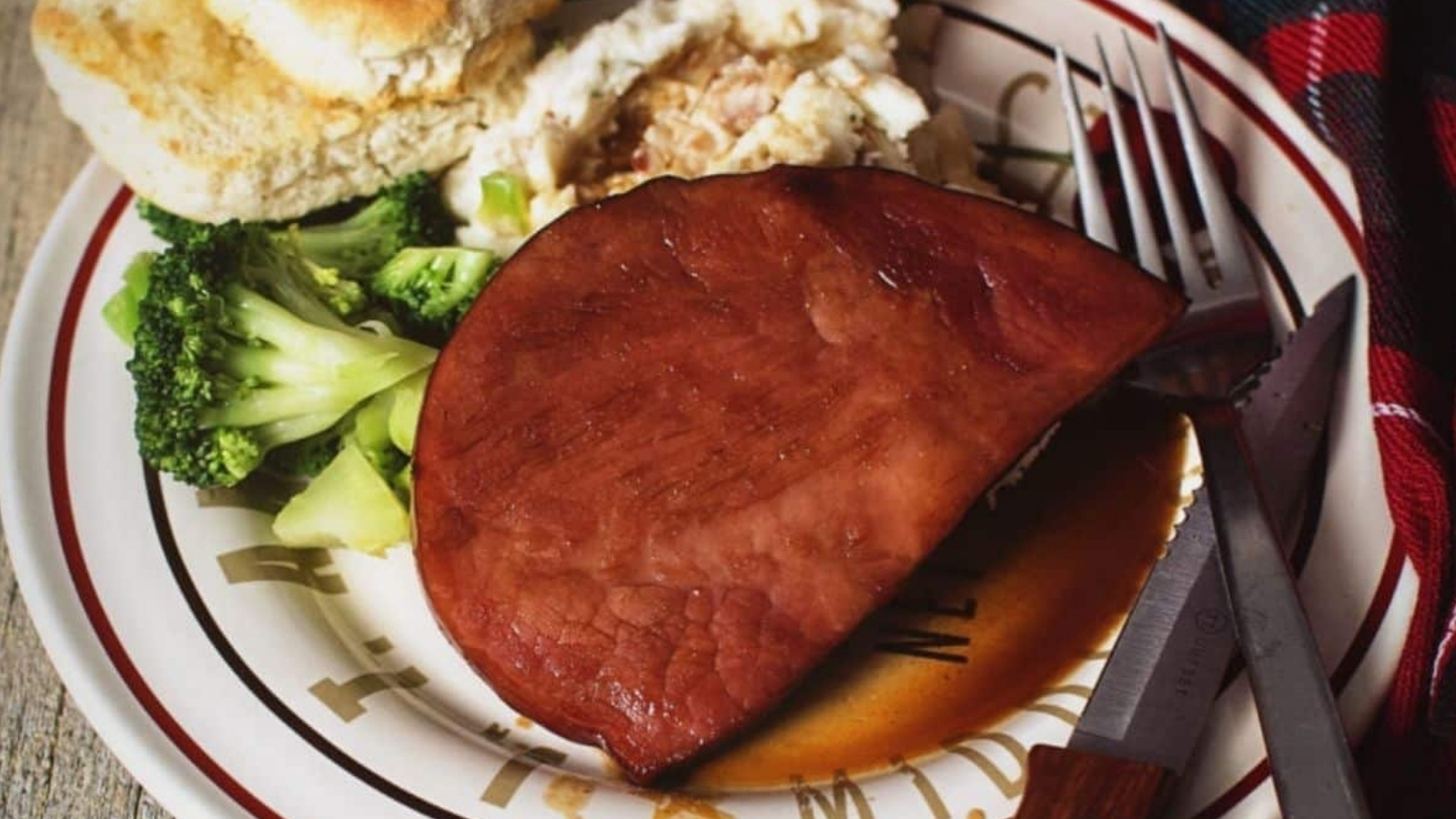 Ham steak glazed with brown sugar caramelizing on edges.