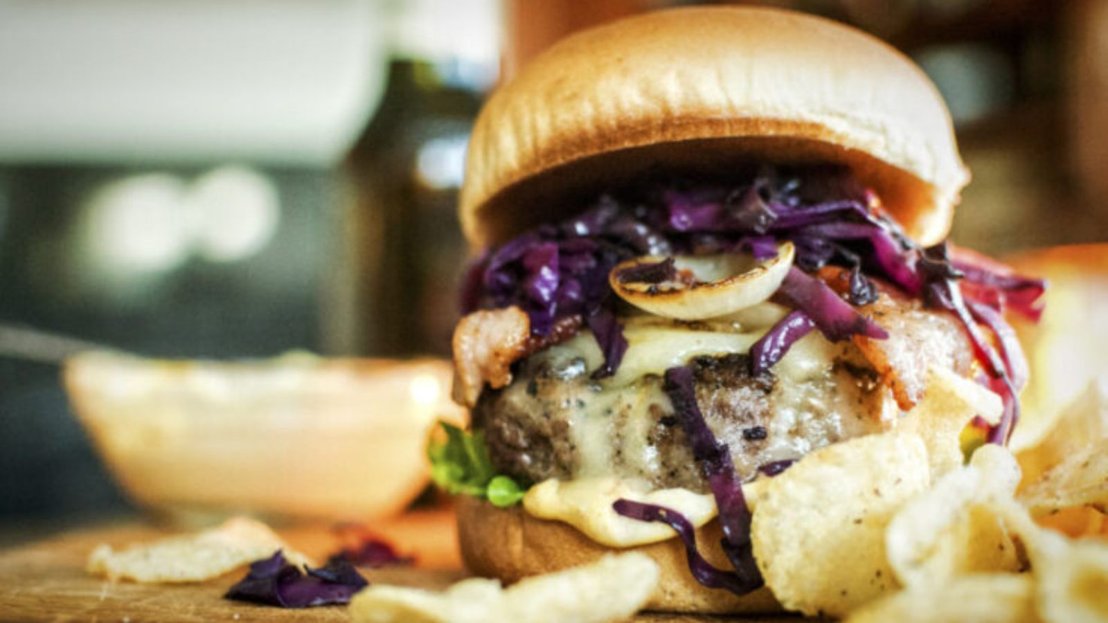 Brat burger topped with sauerkraut and mustard stacked tall on a toasted bun.