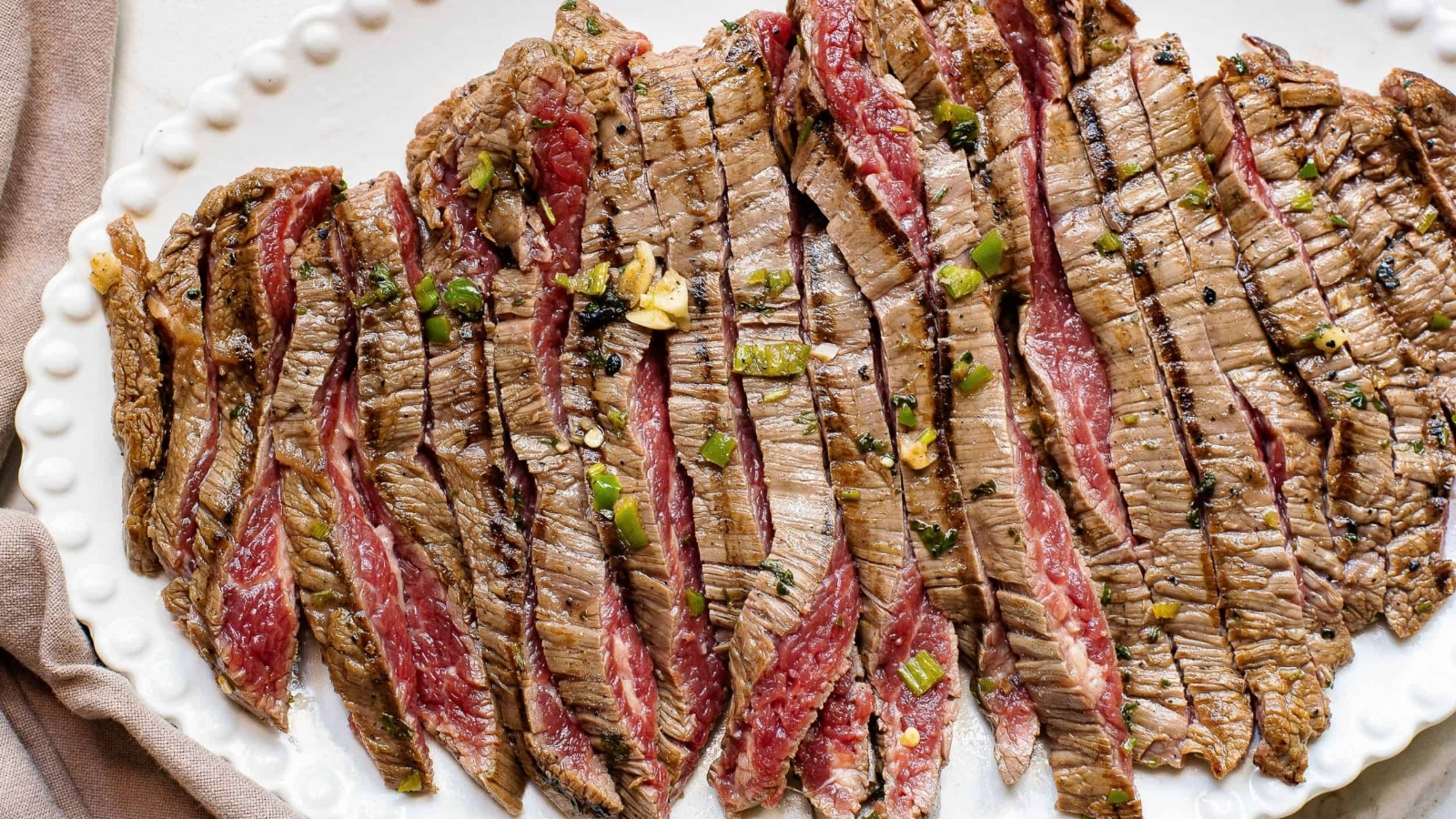 Marinated grilled meat, sliced and on a platter.