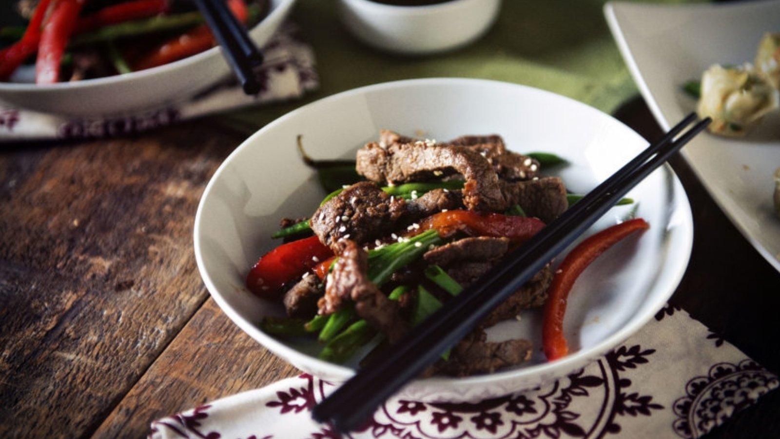 Steak stir fry cooked sesame-style with vegetables in wok.