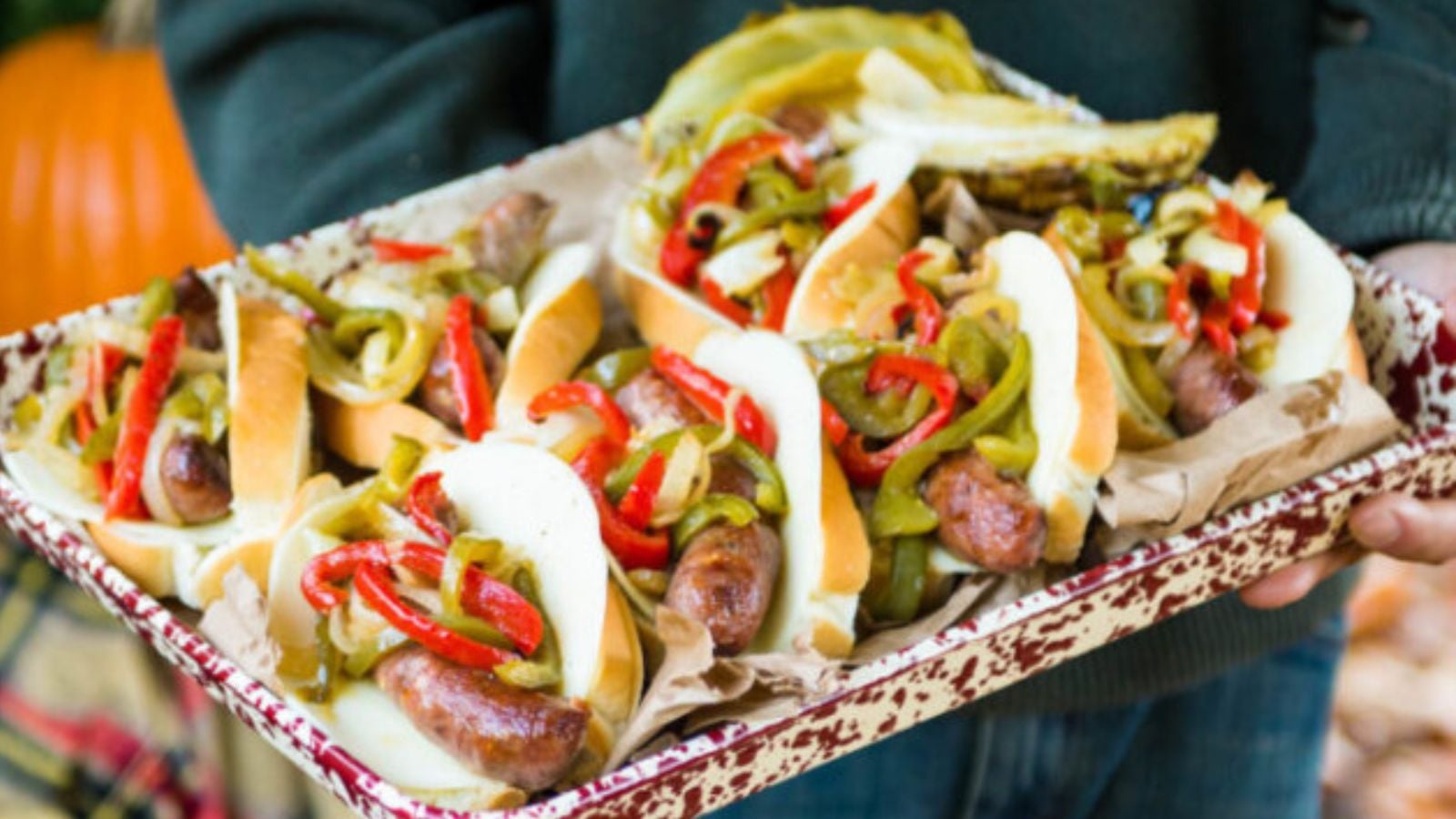 Brats and cabbage braised in beer on a sheet pan with caramelized edges.