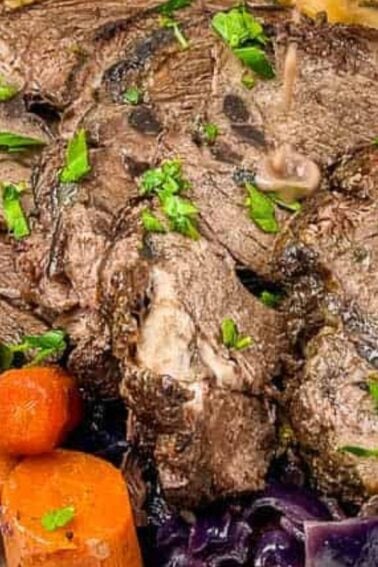 A plate with sliced pot roast, cooked carrots, potatoes, and cabbage, garnished with chopped parsley.