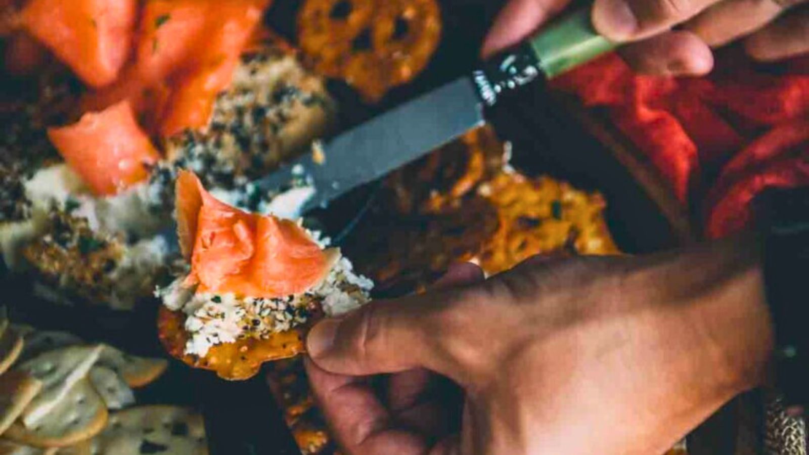 Smoked cream cheese topped with smoked salmon and herbs spread on crackers.