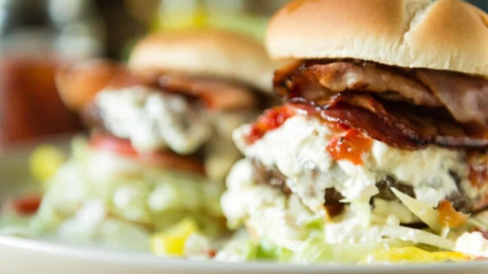 Burger stacked with multiple meats and toppings forming a tall “pick six.”